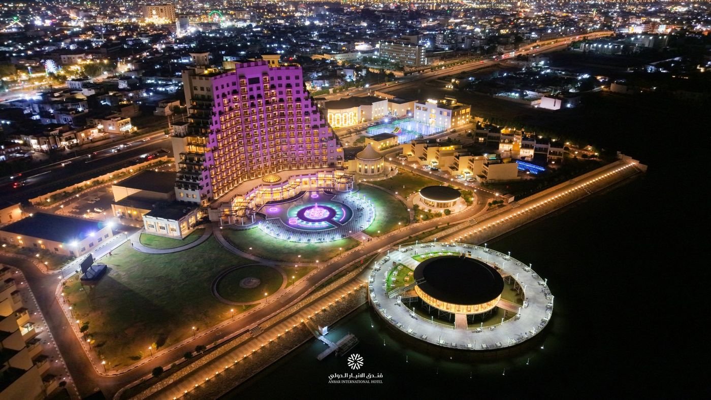 منظر جوي ليلي لفندق الأنبار الدولي والنافورة والمطعم المطل على النهر